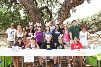 A group of people gathered to pose in front of a tree